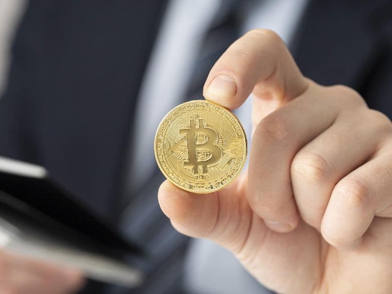 persona sosteniendo moneda ficticia bitcoin.jpg