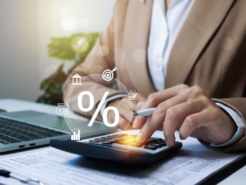 persona con calculadora y simbolos financieros.jpg